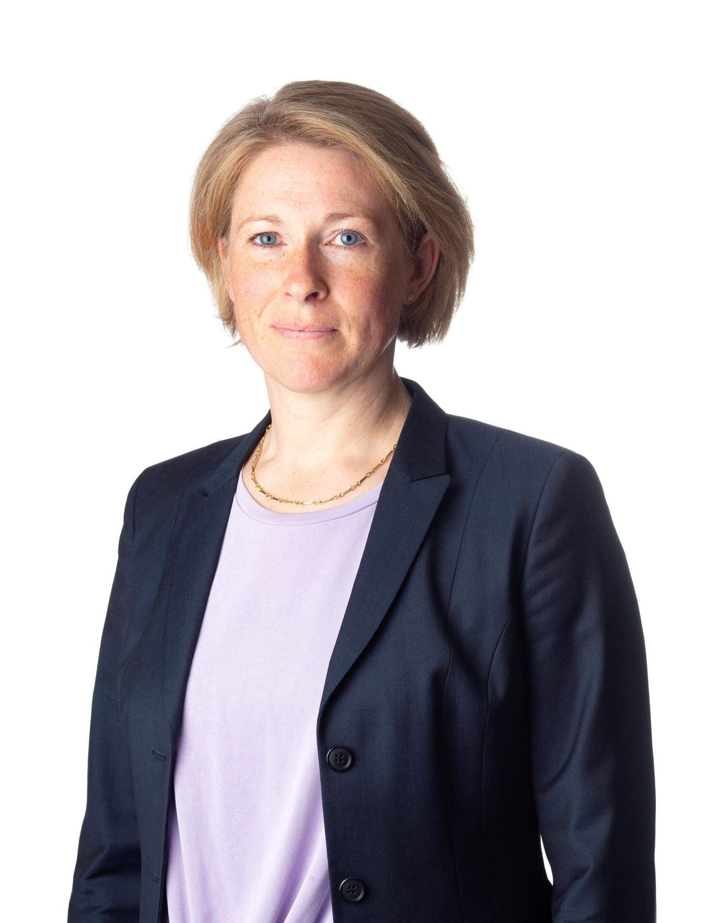 Elin Swedlund står upp och har en blå kavaj