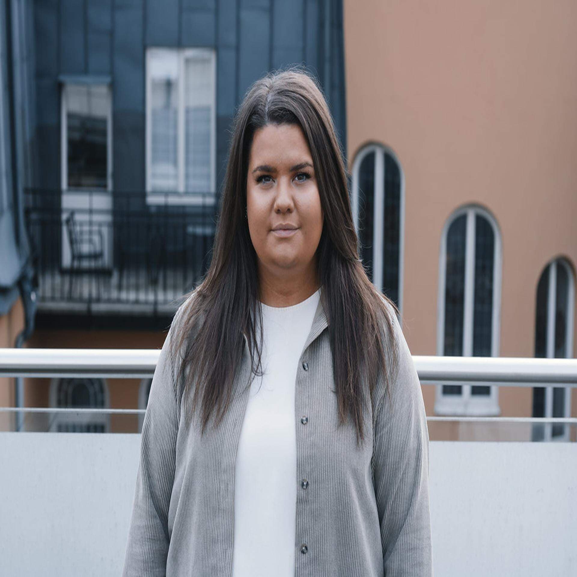 Matilda Ekeblad med en terracottafärgad fasad i bakgrunden