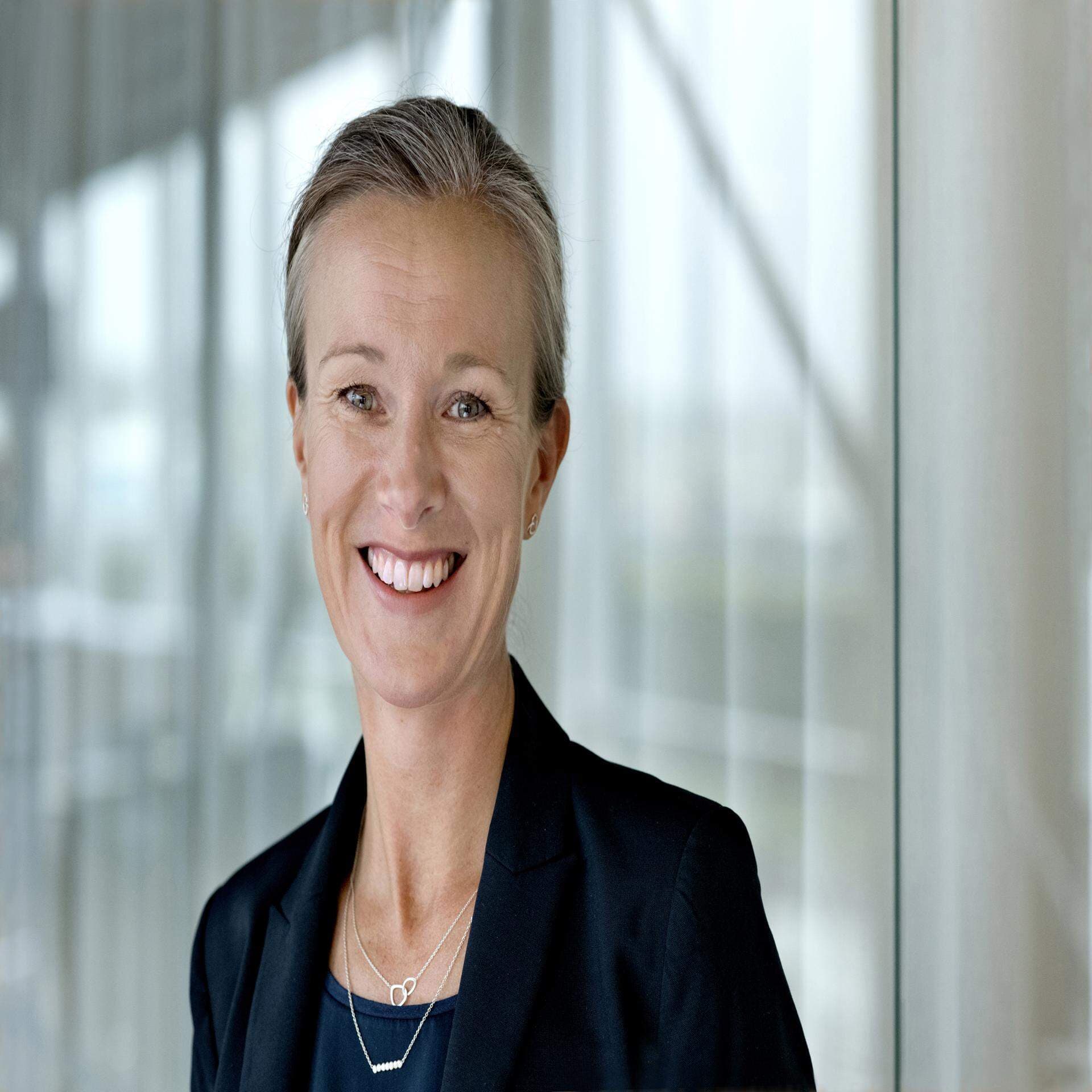 Monica i mörk kavaj och mörkblå topp