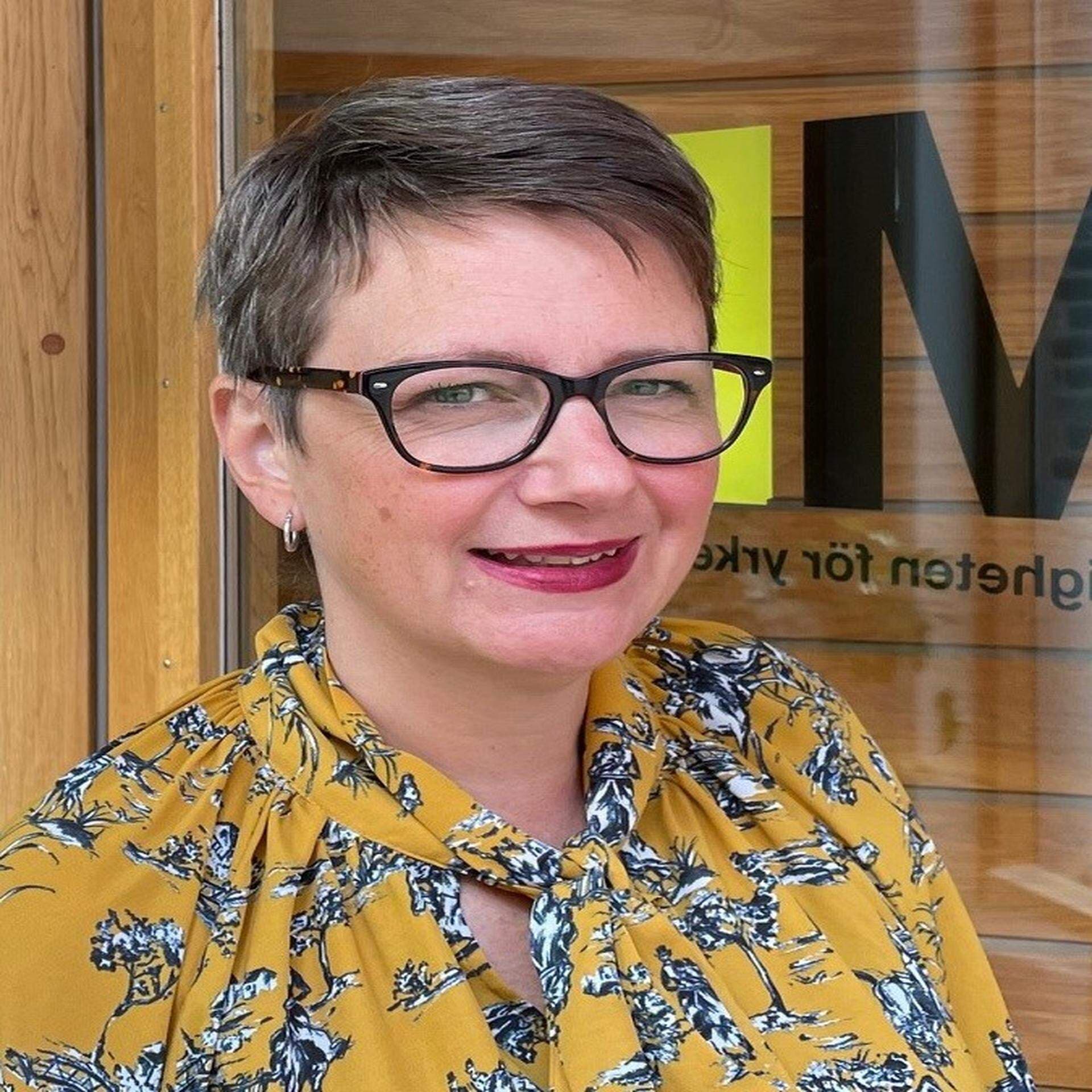 Betina Mohager iklädd gul blus med små blommor på