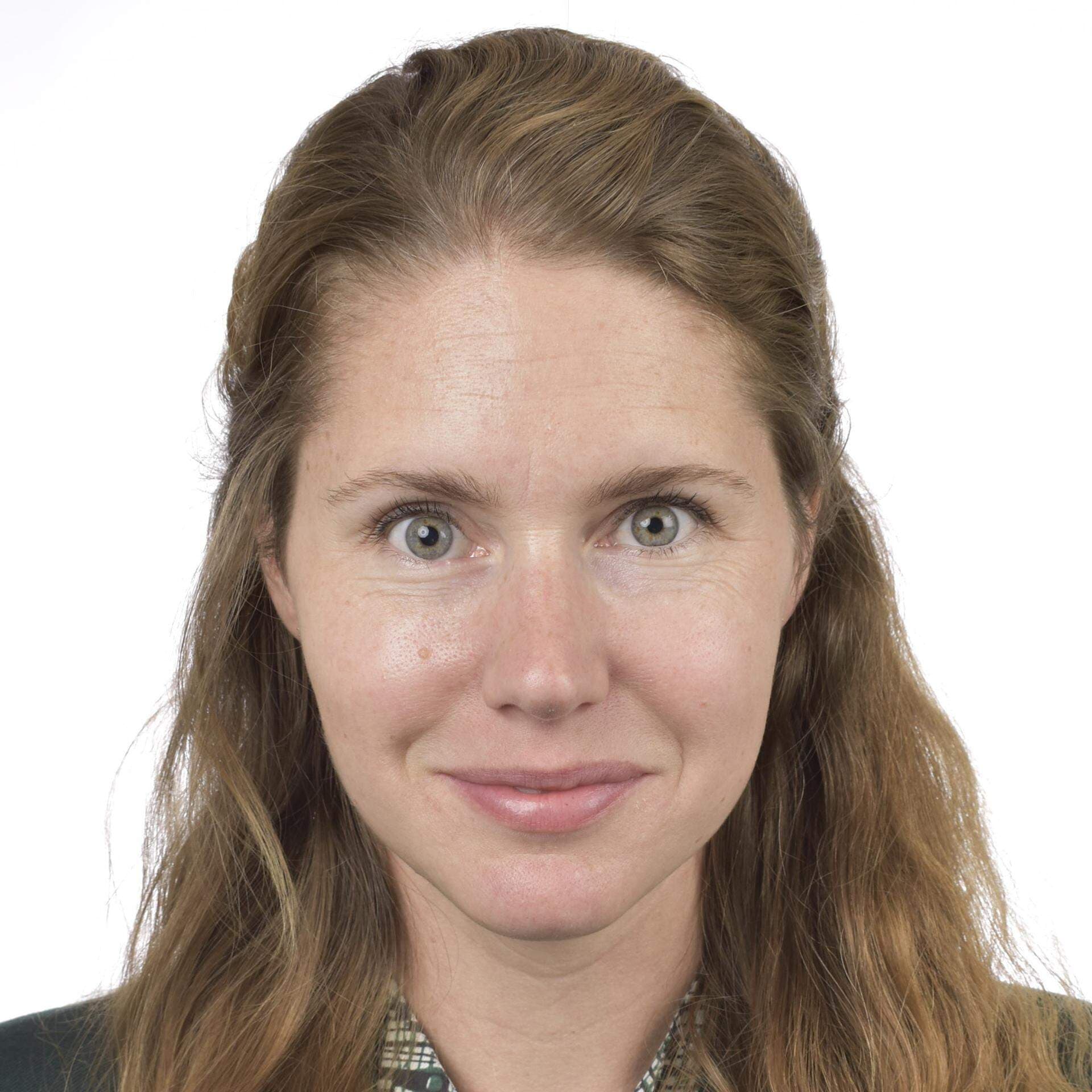 Josefin Malmqvist i småmönstrad blus grön och vit samt mörkgrå kavaj