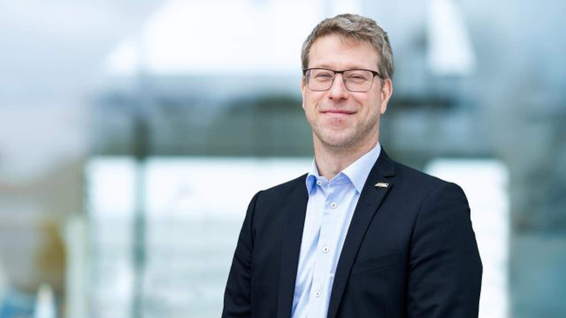 Anders Hermansson står upp och har en blå kavaj