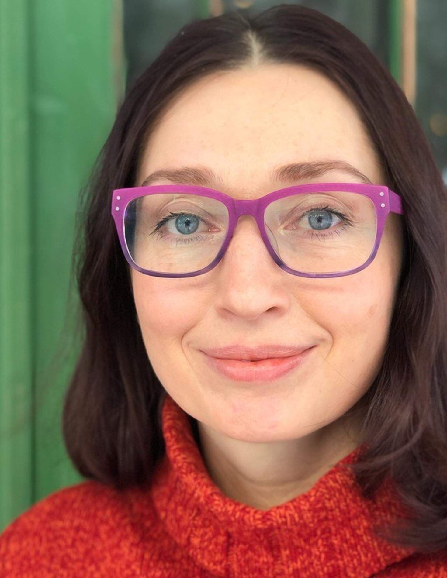 Elena Ahmadi har en röd tröja och lila glasögon