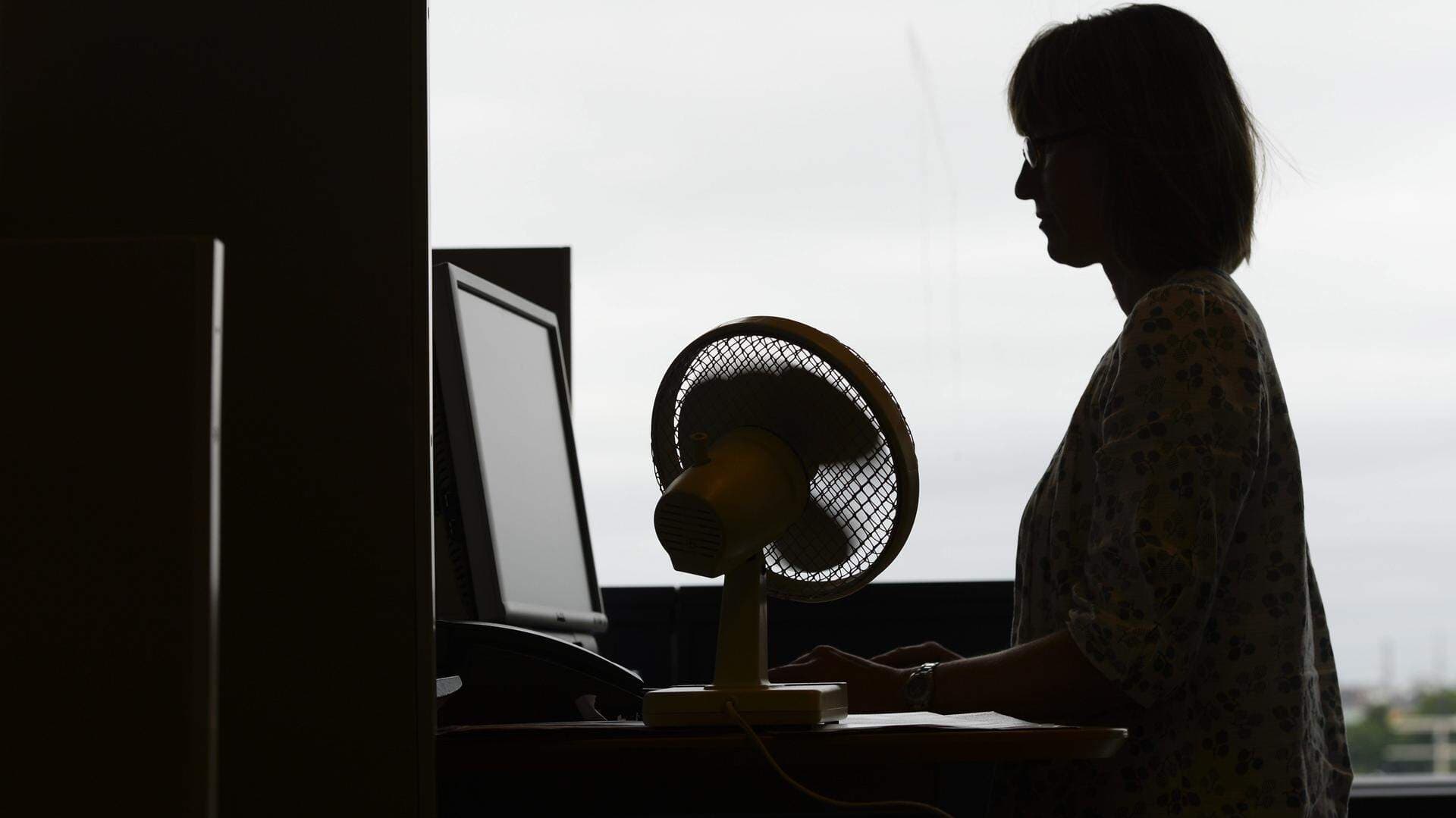 Kvinna i profil stående vid skrivbord