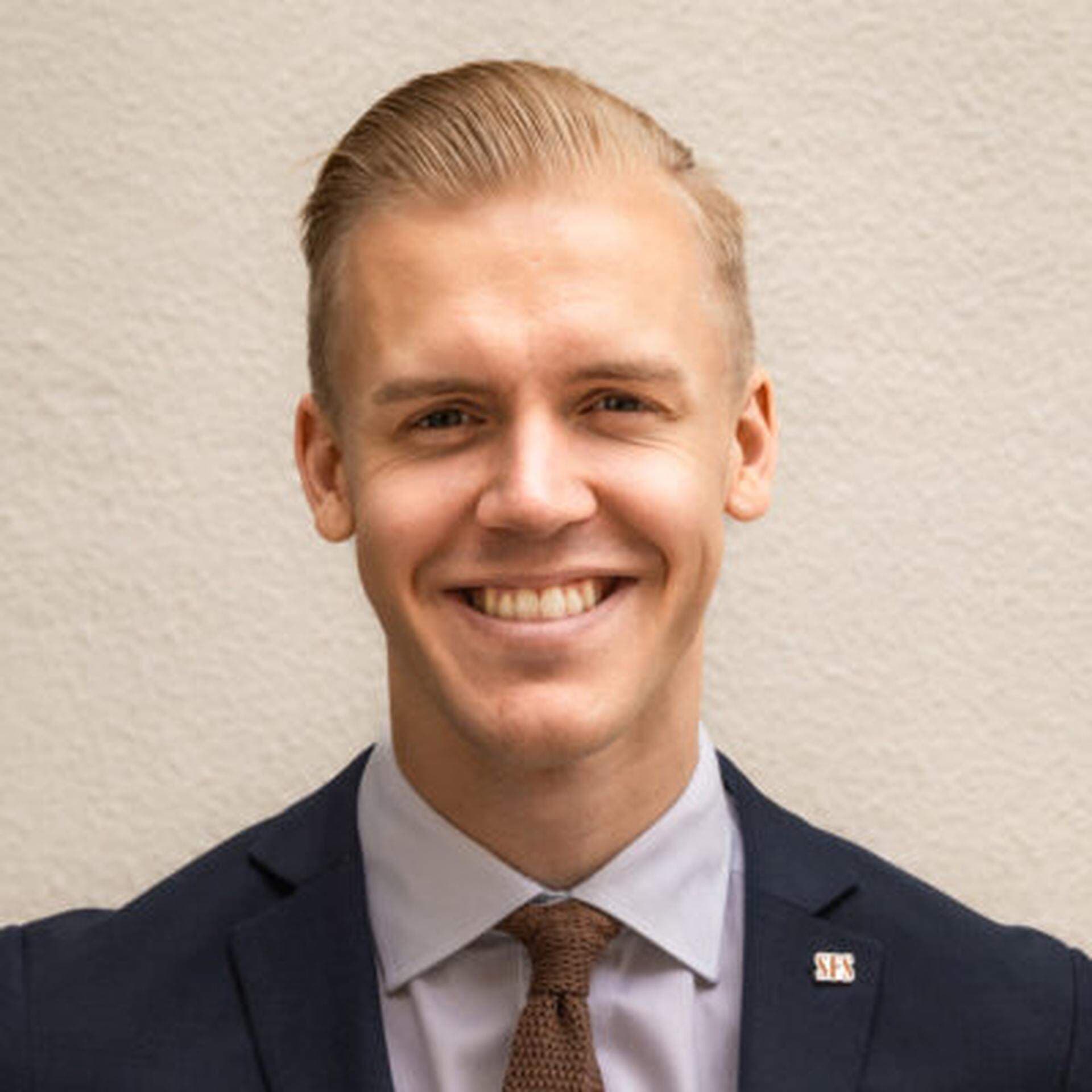 Jacob Färnert i ljusblå skjorta, rödbrun slips och mörkblå kavaj