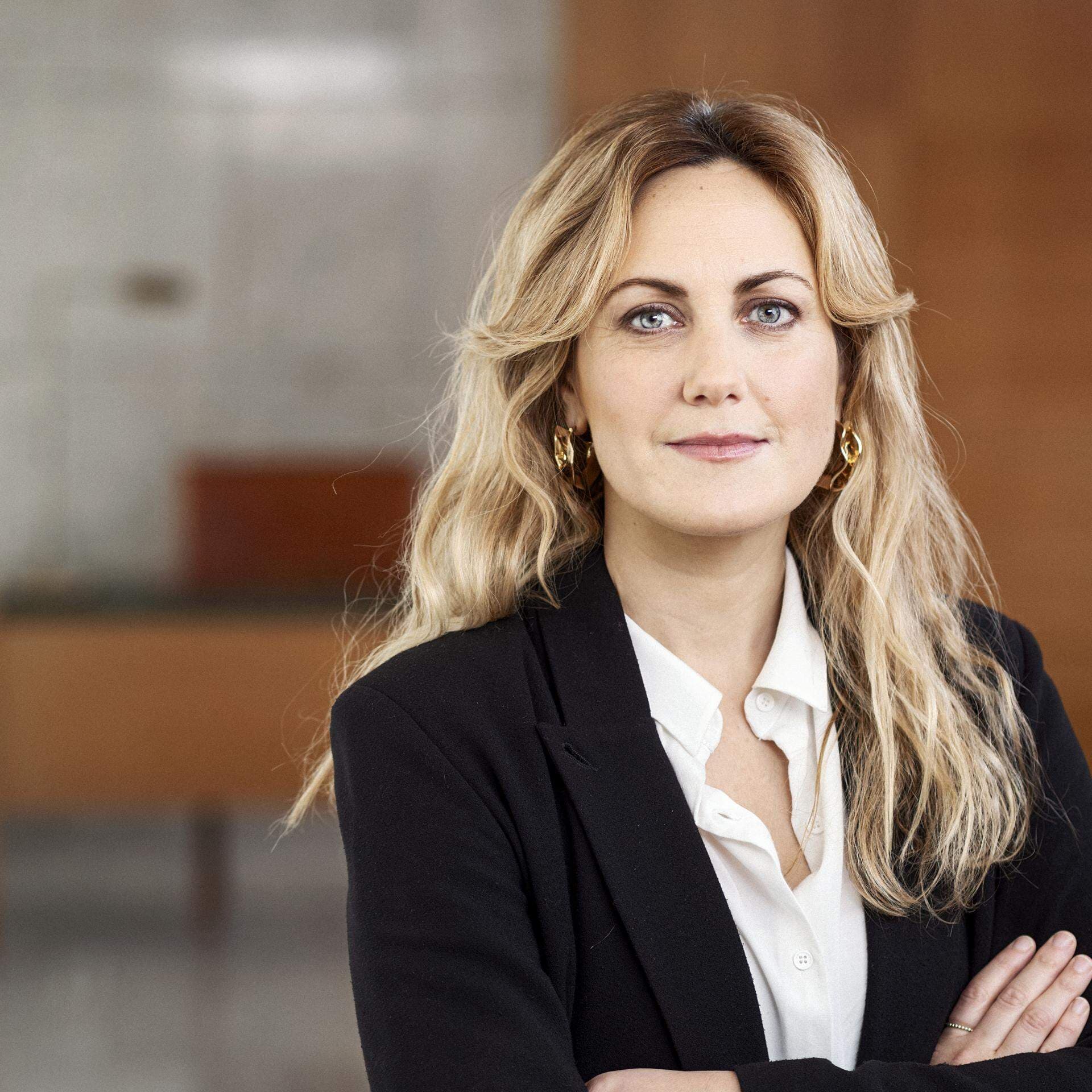Frida Andersson i vit skjorta och svart kavaj i kontorsmiljö