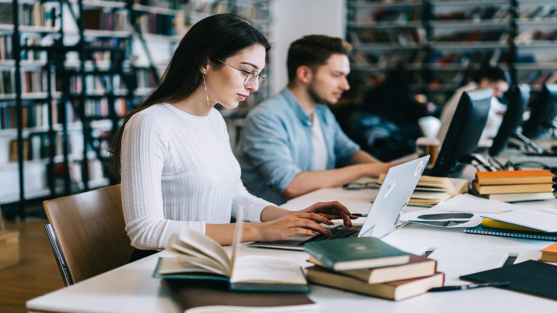 Student på bibliotek med laptop