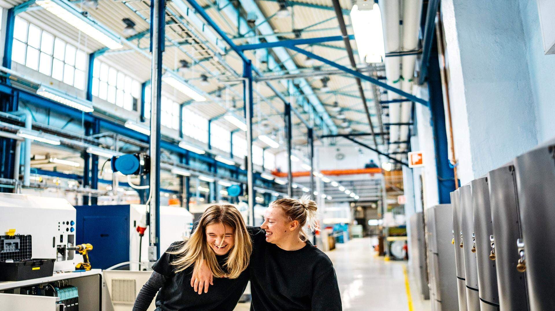Två yrkesarbetande damer i en fabriksmiljö