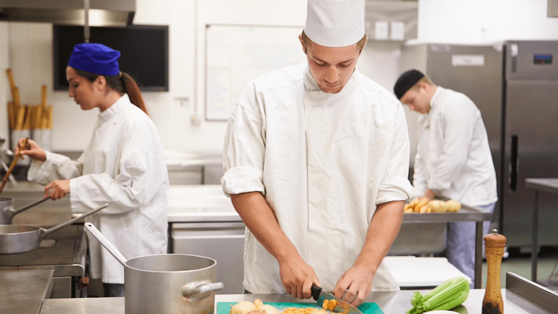 tre unga människor i ett restaurangkök