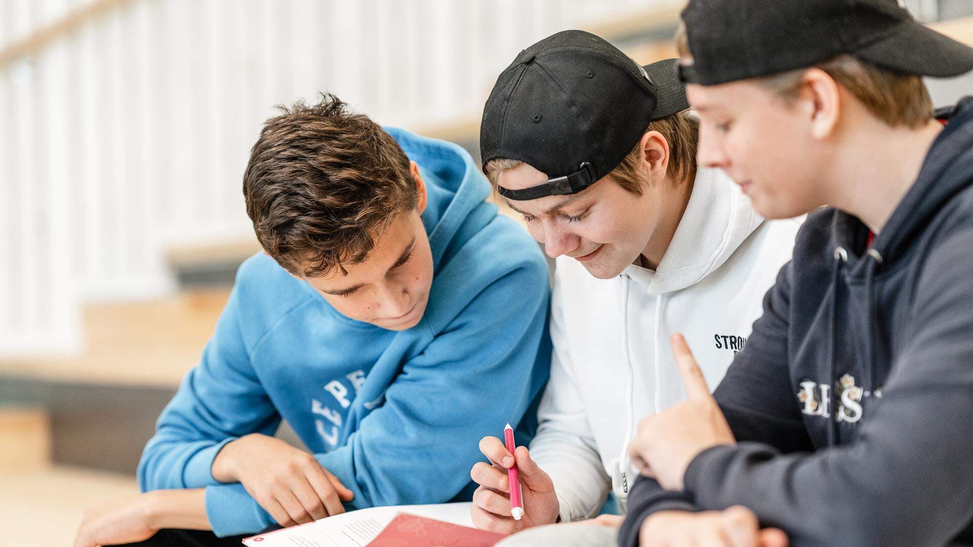 Tre killar som sitter på en trapp