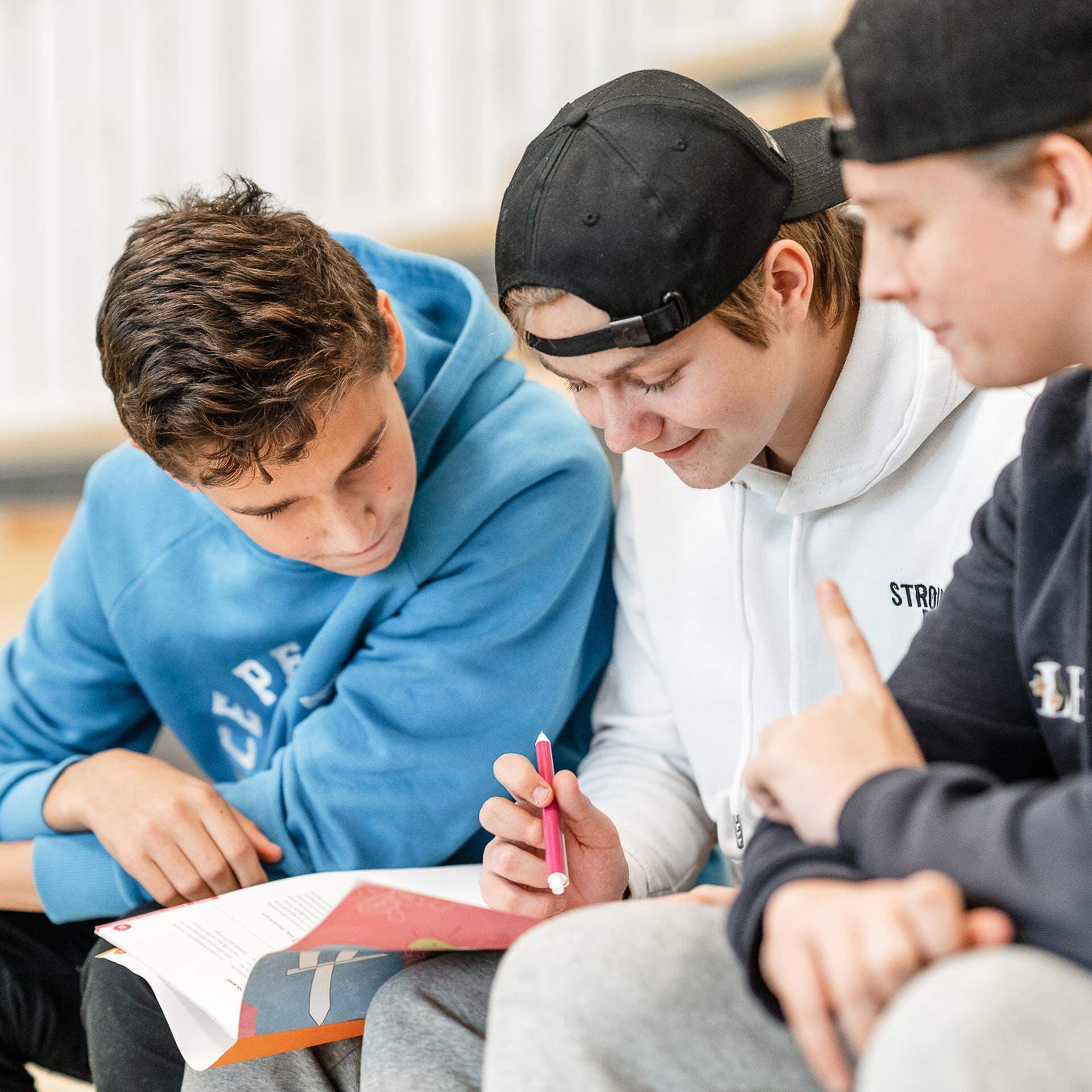 Tre killar som sitter på en trapp