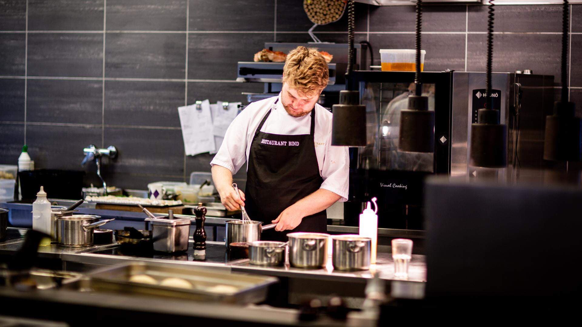 Kock som arbetar i sitt kök