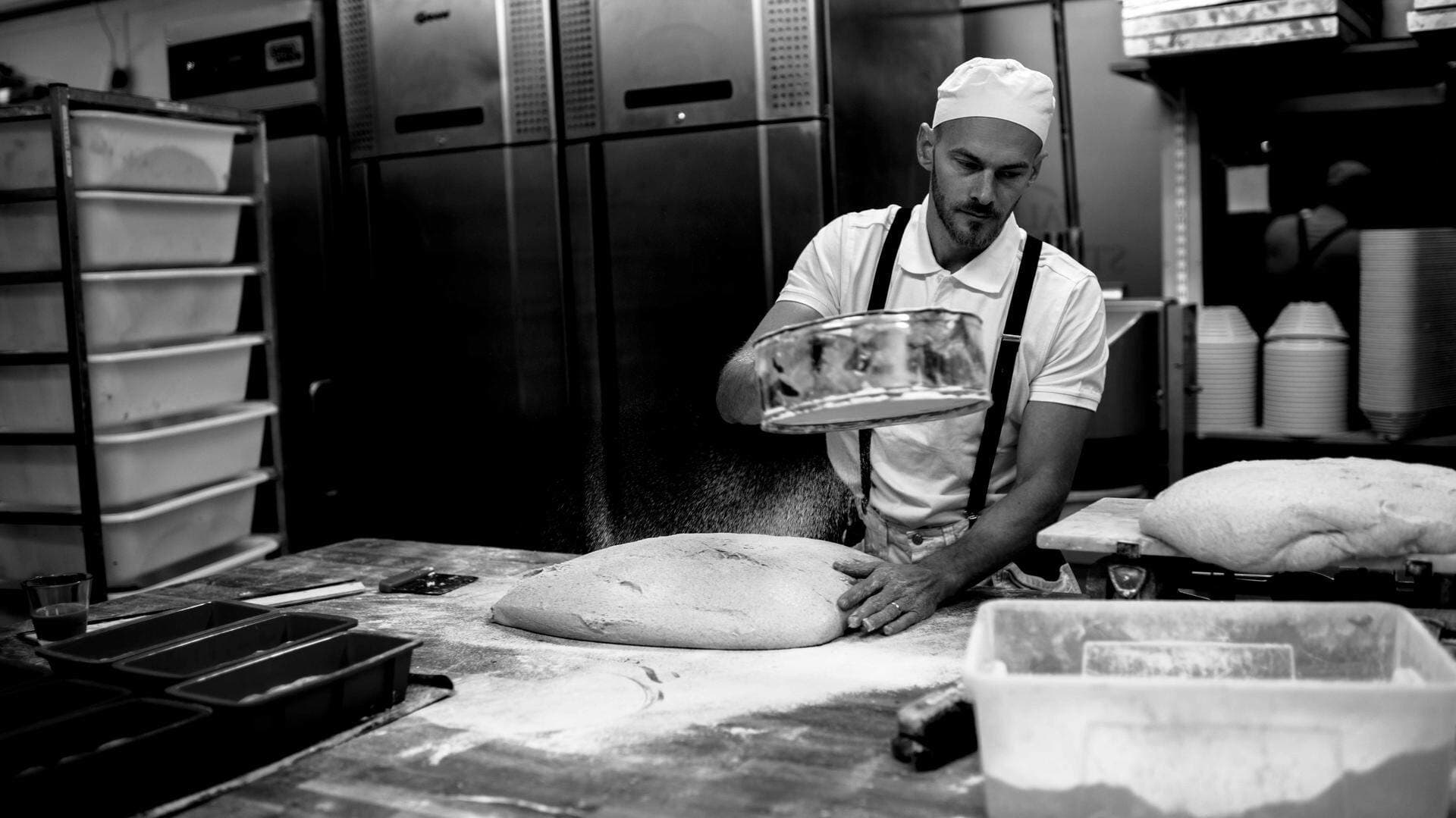 Olof Jönsson siktar mjöl över bröd