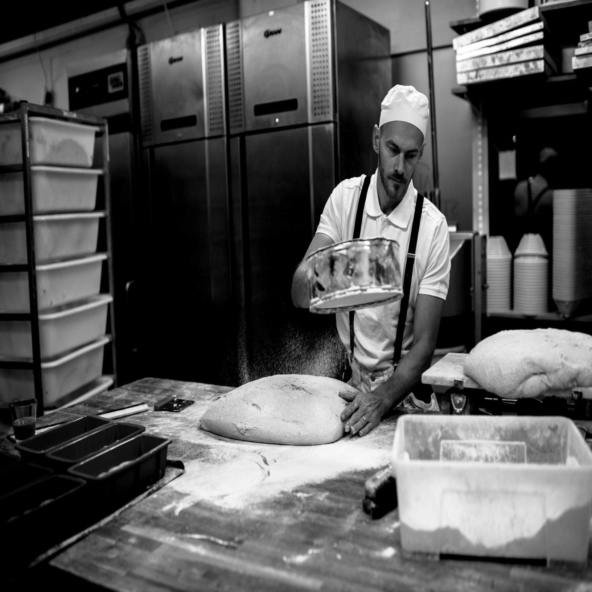 Olof Jönsson siktar mjöl över bröd