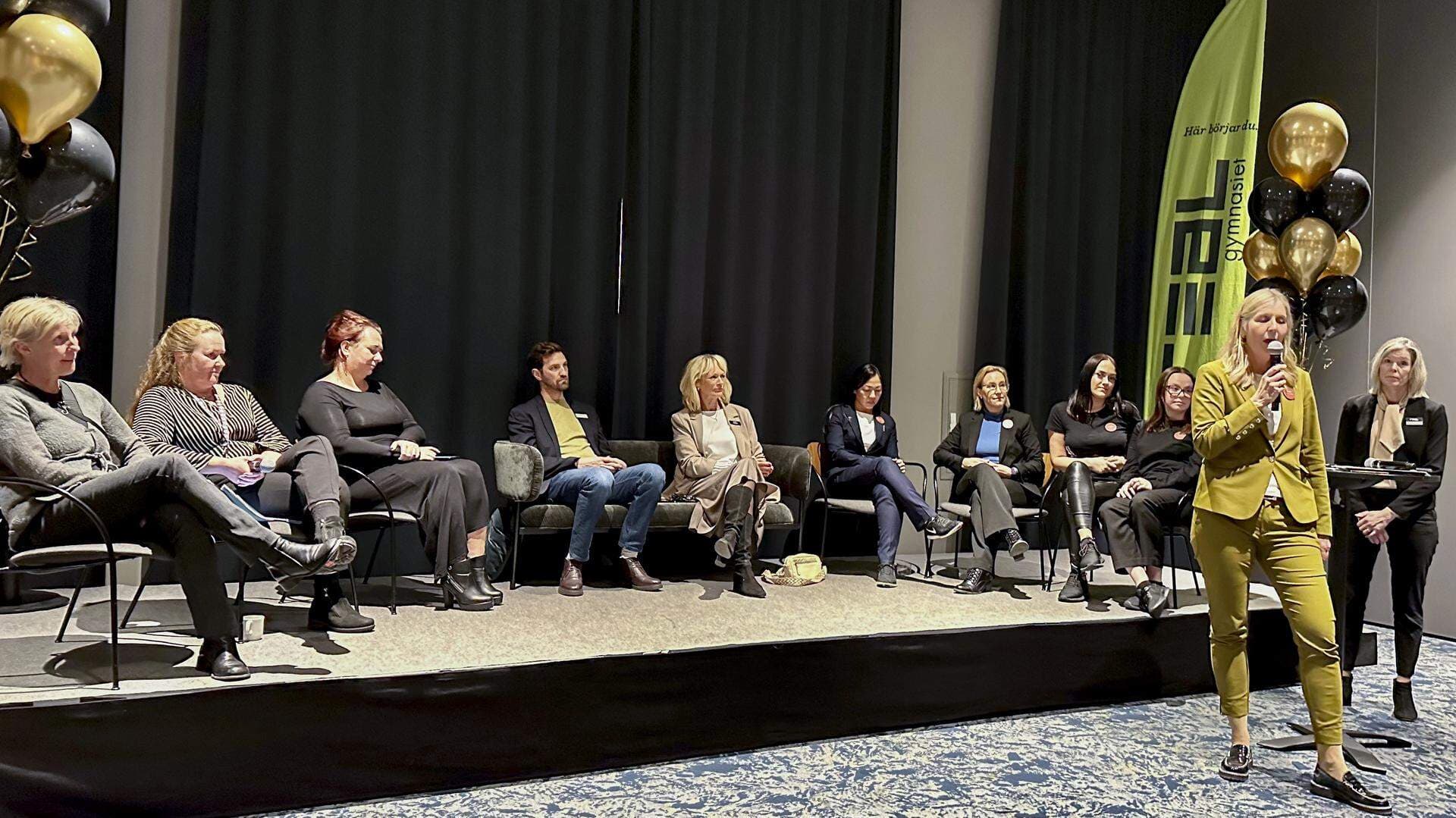 Paneldeltagare sitter på en scen