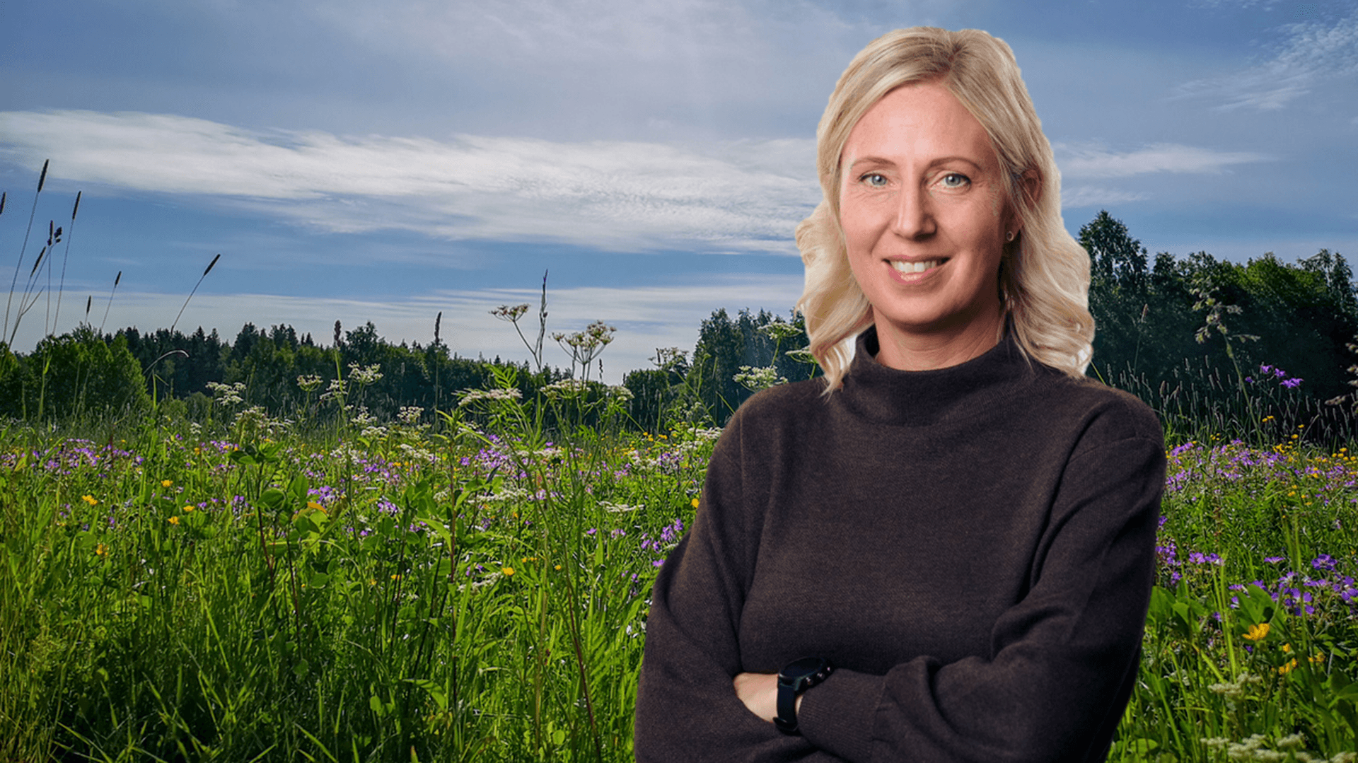 Porträttbild på Eva Nordlander med en sommaräng i bakgrunden