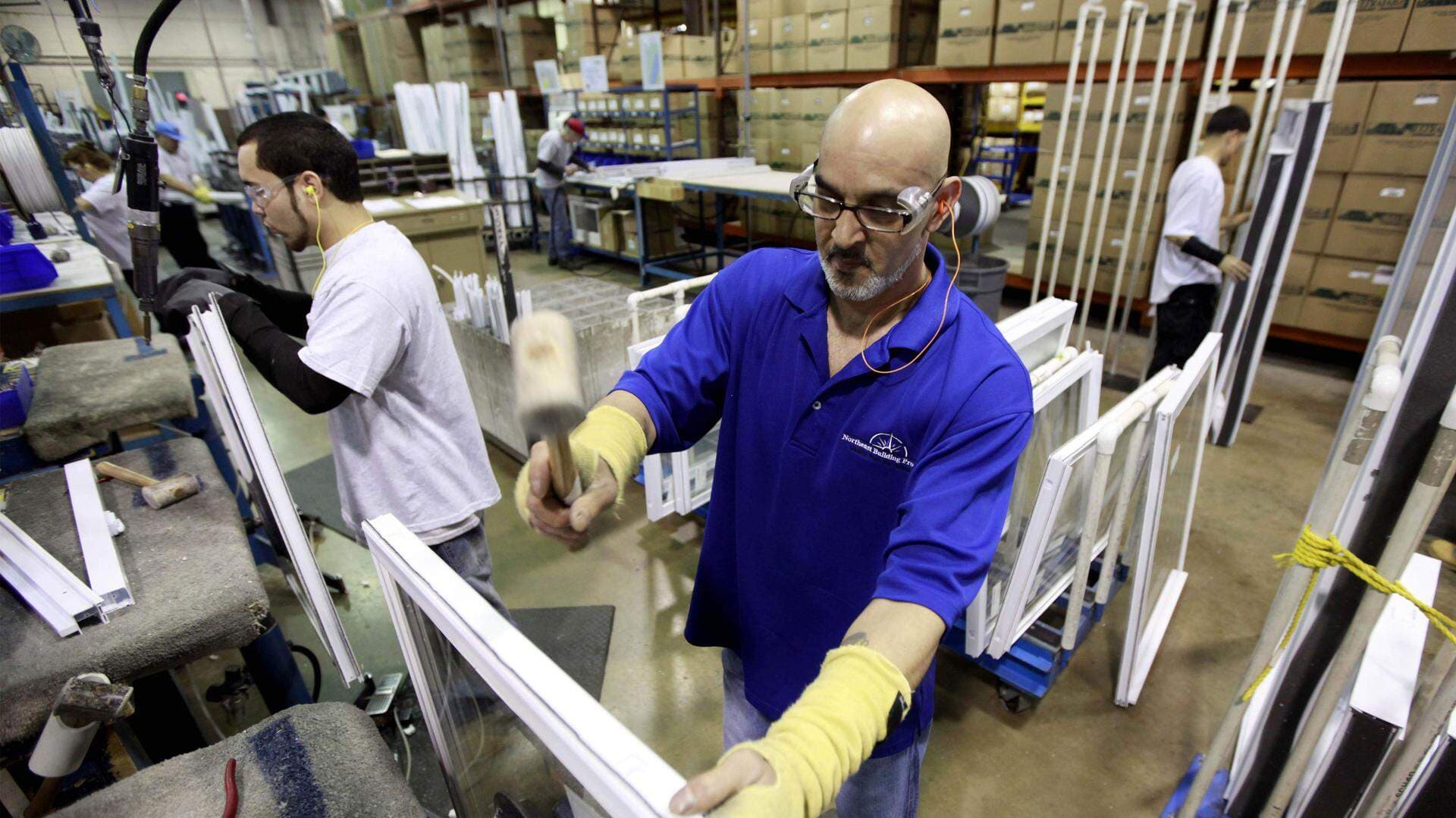 Två rbetare med utländsk bakgrund arbetar i en fabrik