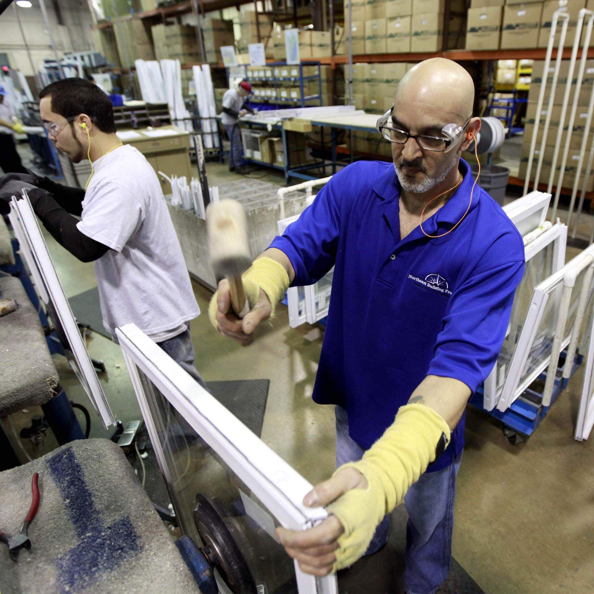 Två rbetare med utländsk bakgrund arbetar i en fabrik