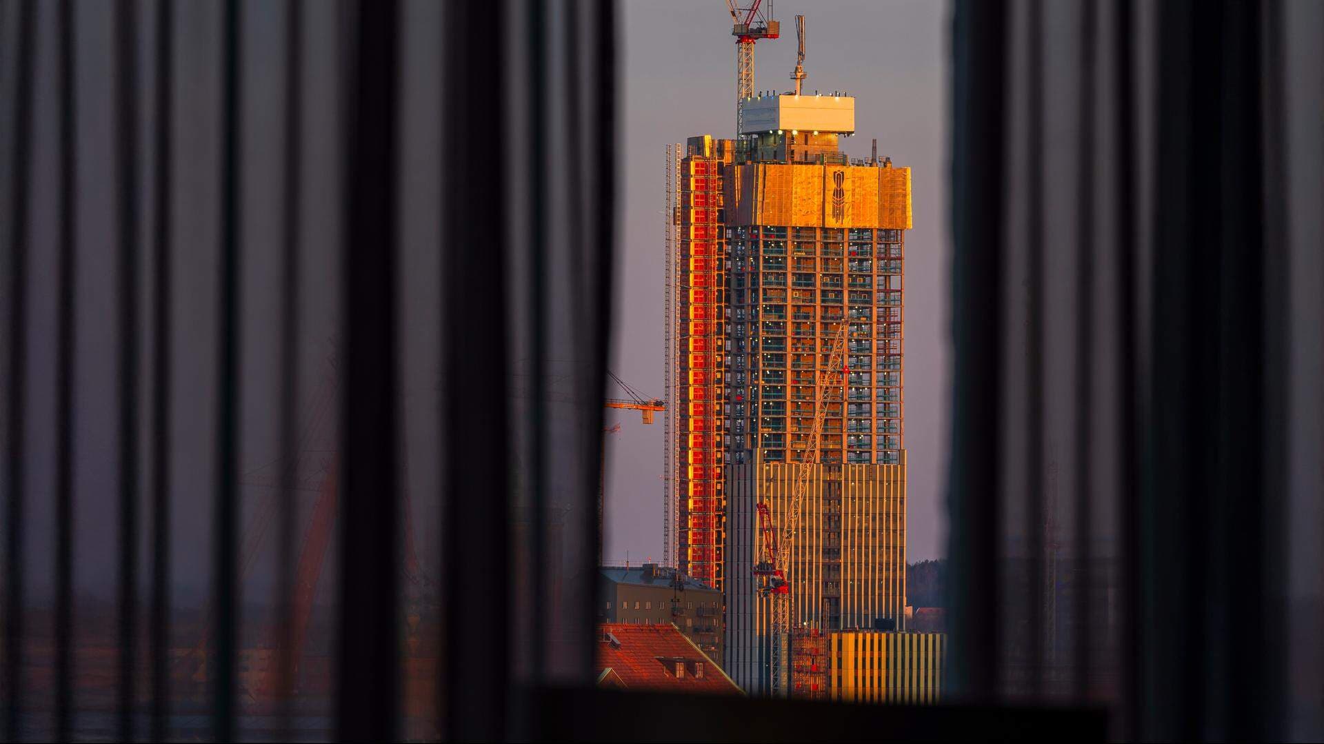 Husbygge i skymningsljus skiktad bakom en gardin